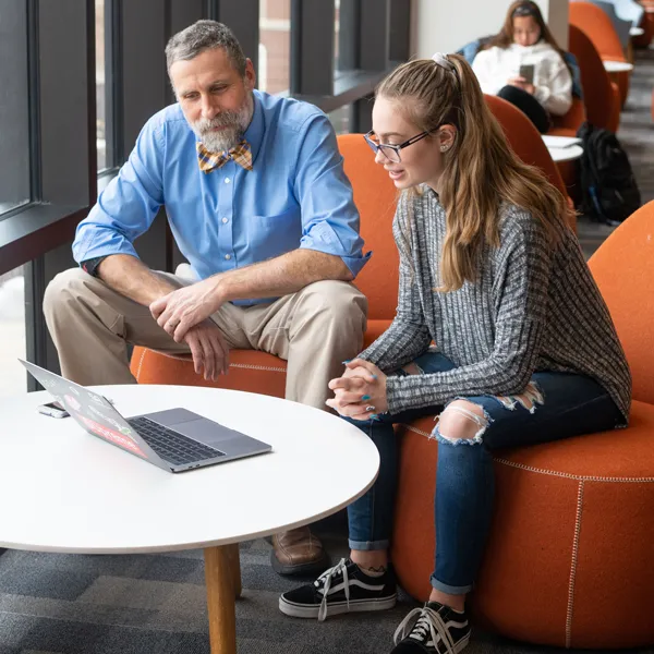 A faculty member assists a student