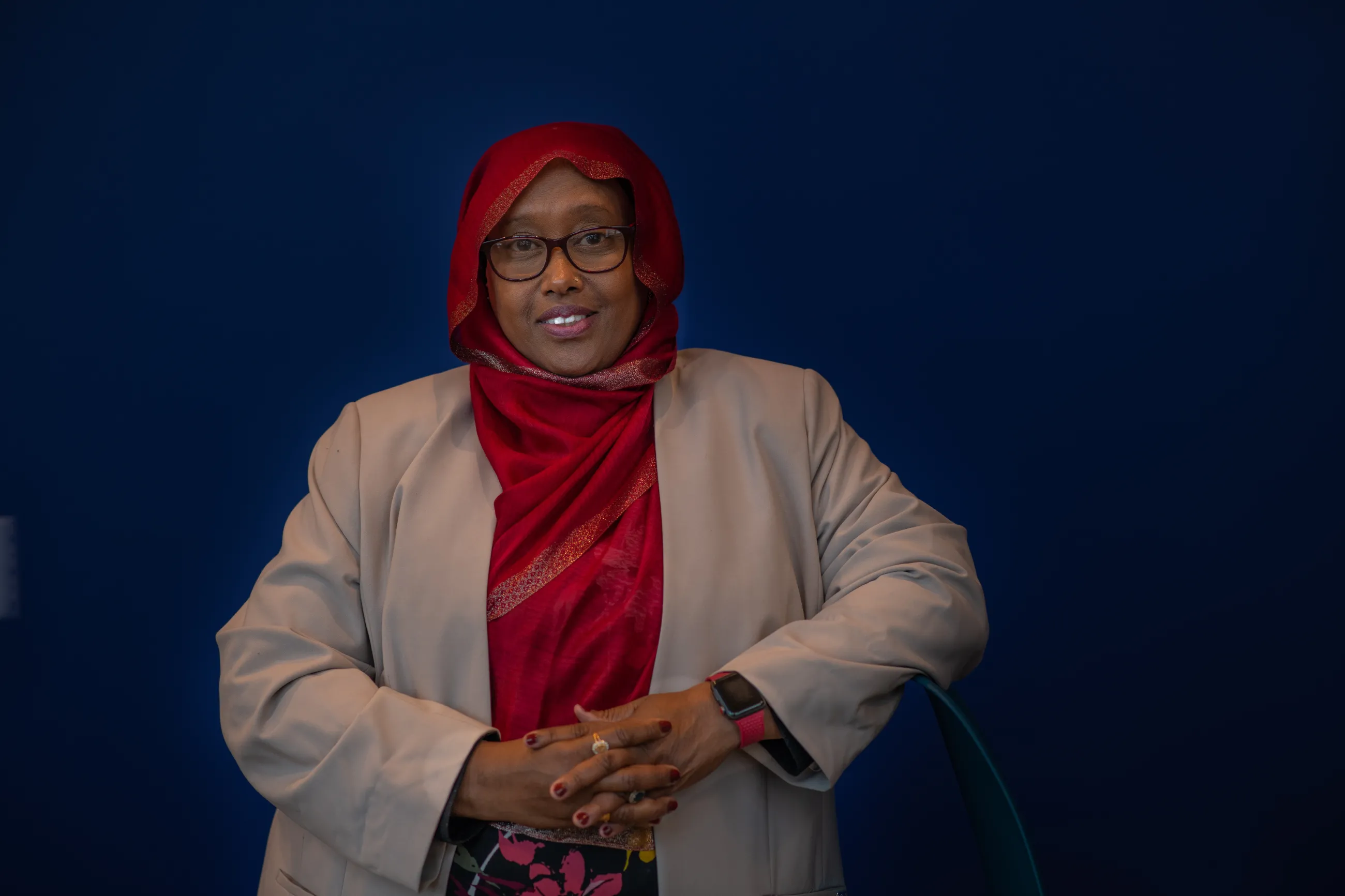 Deqa Dhalac poses for a photo against a dark backdrop