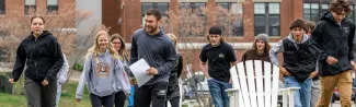 A UNE student leads a group of teenagers through field games