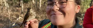 Haley Hines holds a wild bird that Professor Noah Perlut's class will band.