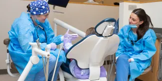 UNE dental students engage with a child patient in the Oral Health Center