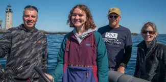 A UNE student poses in a group in