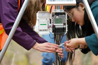 Students tie off a weather monitoring system 