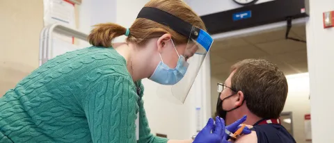 UNE COM student Emily Cathey administers a Moderna COVID-19 vaccine at Maine Medical Center in Portland
