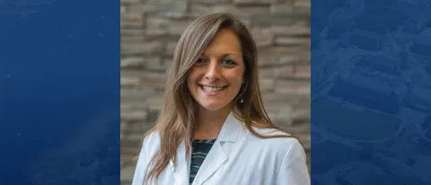 Headshot of Stephanie Podolski against blue backdrop