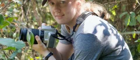 UNE faculty member Maggie Stanton holds a camera in Gombe National Park