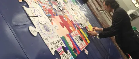 UNE social work student Glenn Simpson unveiled his recovery puzzle at the Southern Maine Harm Reduction Conference 