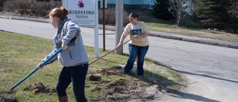 Sarah Nelson (left) and Samantha Funk perform yard work at Biddeford Estates.