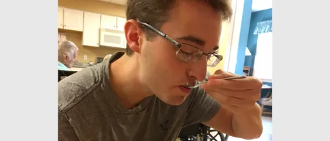 Joshua Allen experiences eating a meal while participating in nursing home immersion project
