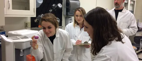 Glenn Stevenson in his lab with students who presented a poster at a national conference
