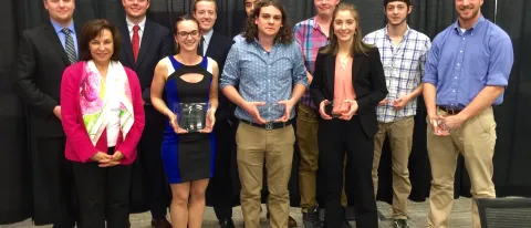 Students who participated in the final round of the Student Innovation Challenge pose with UNE President Danielle Ripich (front,