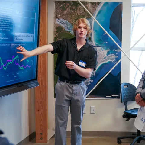 Cropped image of a student presenting weather data on a screen